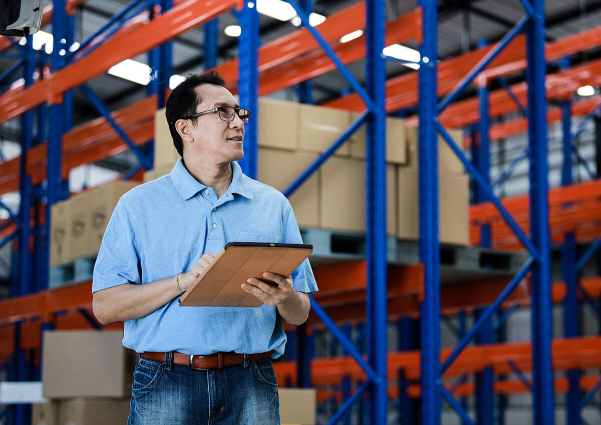Asian man managing warehouse storage business